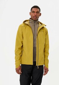 Veste imperméable jaune avec capuche, fermeture éclair frontale et accents noirs. Portée par-dessus une couche intérieure grise, avec une texture lisse.