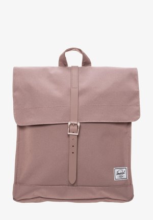 Lichtpaarse stoffen rugzak met een bovenklep die wordt vastgehouden door een centrale gesp en een klein logoplaatje rechtsonder.