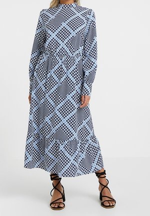 Vestido de manga larga y largo medio con un patrón geométrico en negro, blanco y azul claro, con un escote redondo y una cintura fruncida.