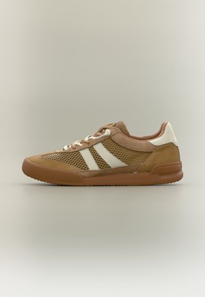 Bruine en beige lage sneakers met mesh-zijden, witte zijstrepen, witte veters en een rubberen zool op een neutrale achtergrond.