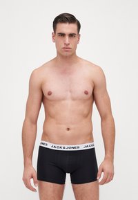 Black cotton boxer briefs with a white "JACK & JONES" logo on the waistband, featuring a fitted design and smooth texture.