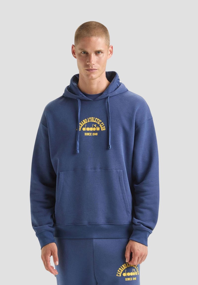 Felpa blu navy con tasca frontale, caratterizzata da un logo grafico giallo. Realizzata in tessuto morbido, con cappuccio regolabile e polsini a costine.