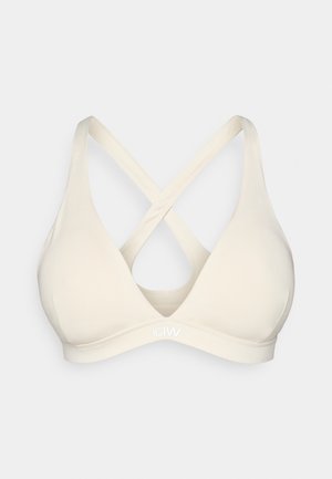 Hellbeige Dreieck-Bralette mit überkreuzten Trägern. Hergestellt aus glattem Stoff mit einem Logo am Bund, das ein minimalistisches Designelement hinzufügt.