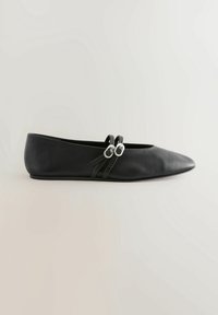 Chaussure plate en cuir noir avec bout pointu et deux fines brides fixées par des boucles ovales argentées sur fond neutre.