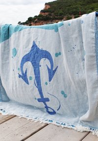 Blue and light blue patterned towel featuring a large dark blue anchor design, fringed edges, and a soft, textured fabric.