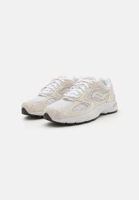 Lysfarvede sneakers med overdel i mesh og ruskind, prydet med hvide snørebånd, subtile detaljer og en struktureret gummisål.
