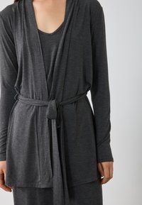Gray long-sleeve wrap cardigan in soft fabric, featuring a V-neck, tied waist, and relaxed fit with a smooth texture.