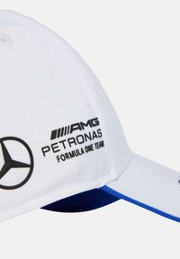Witte honkbalpet met een blauwe accent. Voorzien van zwarte bedrukte logo's: AMG, Petronas en Formula One Team. Zachte stof, gestructureerde rand.