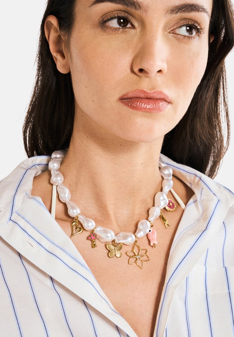 Helmi-kaulakoru, jossa on epäsäännöllisiä muotoja ja kultaketjuja, mukaan lukien sydän, kukka, perhonen ja värikkäitä yksityiskohtia.
