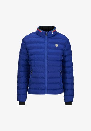 Blauwe pufferjas met een gewatteerd ontwerp, staande kraag, rits aan de voorkant, zijzakken en zwarte geribde manchetten. Heeft een logo op de borst.