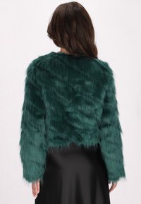 Jachetă din blană artificială teal, cu design scurt, mâneci lungi și o suprafață moale, texturată. Vedere din spate, fără închideri sau accente vizibile.