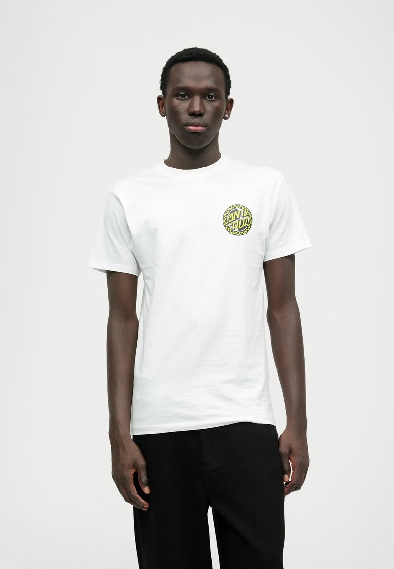 Λευκό βαμβακερό μπλουζάκι με κυκλική μαύρη και νεον κίτρινη γραφική απεικόνιση στην αριστερή περιοχή του στήθους. Σύντομες μανίκες και σχέδιο με λαιμόκοψη crew.