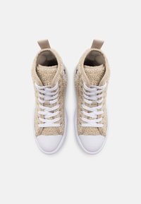 Högklackade sneakers i beige texturerat tyg med vita skosnören, gummitoyor och en kontrasterande tanfärgad häldetalj. Märkbart logo på sidan.