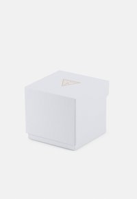 White textured paper box with a triangular gold logo on the top. It has a simple, geometric shape with a flat lid and open base.