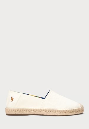 Espadrille en toile de couleur écru avec une semelle en corde. Présente un revêtement intérieur à motifs bleus et un petit logo brodé sur le talon.