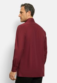 Bordeaux lange mouwen overhemd met knoopsluiting, gemaakt van een gladde stof, met een klassieke kraag en knoopmanchetten. Slim fit met rugdeel detail.