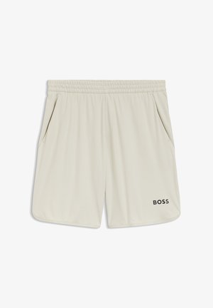 Beżowe szorty sportowe z elastycznym pasem, bocznymi kieszeniami oraz widocznym czarnym logo na dolnej lewej stronie. Gładka, lekka tkanina.