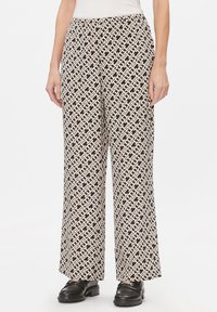 Pantaloni a gamba larga con un motivo geometrico in bianco e nero, realizzati in un materiale leggero con una texture liscia. Vita elasticizzata.