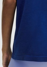 Kurzarmliges Sporthemd in Dunkelblau, mit strukturiertem Stoff und geradem Saum, sowie einer seitlichen Taschenansicht.