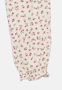 Hvit stoff med blomsterdesign i rosa og rødt, med grønne stengler, samlet elastisk kant og myk tekstur.