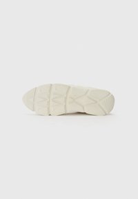 Vásárlásra alkalmas sneaker talp, textúrált gumiból készült, szegmensekre osztott kialakítással, törtfehér színben, és kitapintható tapadási mintázattal.