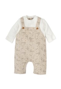 Peto beige con vehículos y estrellas impresos, con botones de madera, y una camiseta de manga larga blanca debajo. Material de algodón suave.