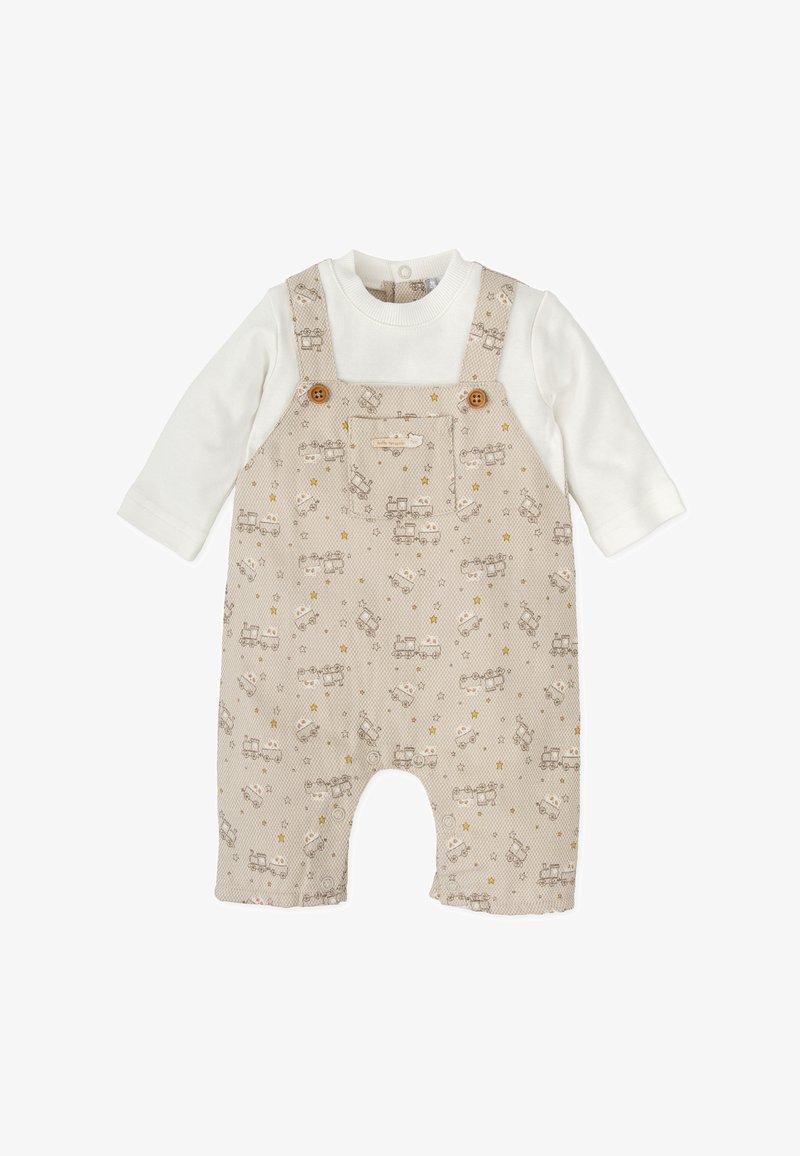 Peto beige con vehículos y estrellas impresos, con botones de madera, y una camiseta de manga larga blanca debajo. Material de algodón suave.