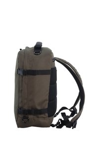 Zaino verde oliva scuro con superficie texturizzata, spallacci regolabili, fibbia laterale e pannellatura in rete per ventilazione.