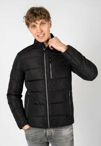 Giacca a vento nera con colletto alto, chiusura con zip e due tasche laterali. Presenta una texture trapuntata e un design slim fit.