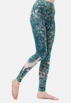 Leggings in een groen bloemenpatroon met bladeren en roze bloemen, met een speelse dierenaccent. Gemaakt van rekbare stof.