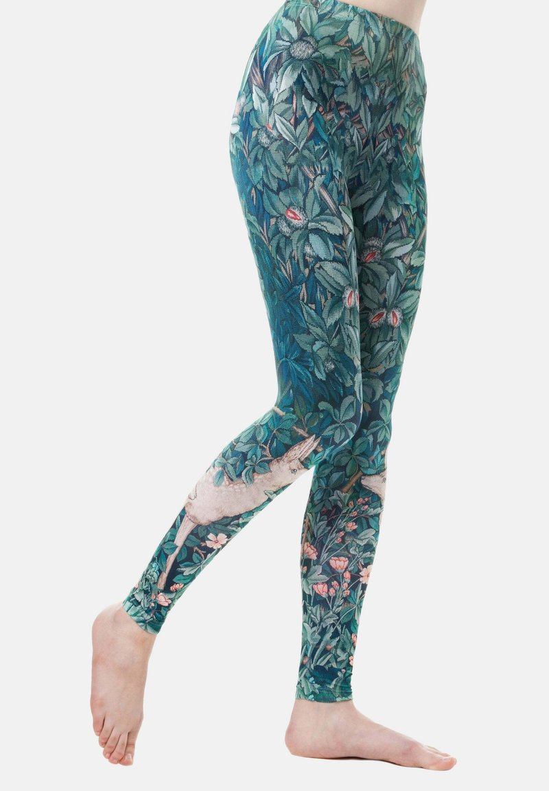 Leggings in een groen bloemenpatroon met bladeren en roze bloemen, met een speelse dierenaccent. Gemaakt van rekbare stof.