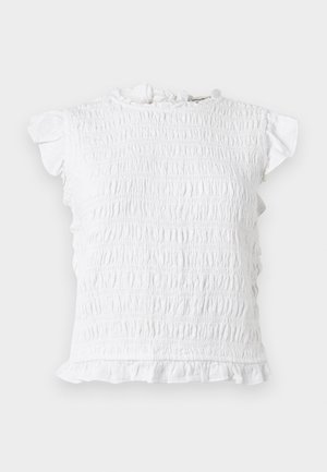 Λευκή μπλούζα με κοντά μανίκια και σμόκινγκ, με βολάν στο γιακά, στα μανίκια και στο τελείωμα, απλωμένη επίπεδη σε ανοιχτό φόντο.