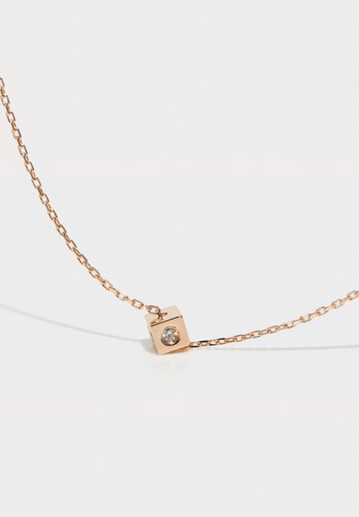 Halskette in Roségold mit einer strukturierten Kette und einem Würfelanhänger, der einen klaren Edelstein in der Mitte hervorhebt und geometrische Designelemente betont.