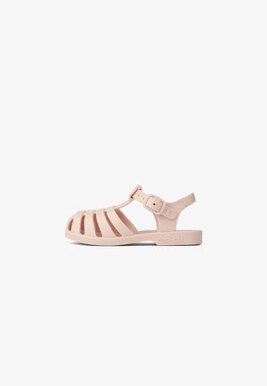 Light pink, rubber sandal with open-toe design, multiple horizontal and vertical cutouts, adjustable strap, and logo on side.