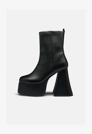 Schwarzer Leder-Stiefelette mit dicker Plateausohle und weitem, ausgestelltem hohen Absatz, glatter Textur und kleinem Logo nahe dem oberen Rand.