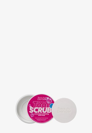 Detergente solido per la pulizia in un contenitore bianco con un'etichetta rosa. Il testo recita "Tool SCRUB" e "sapone solido esfoliante senza profumo."