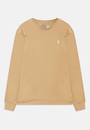 Bēšas krāsas garām piedurknēm T-krekls ar apaļu kakla izgriezumu, izgatavots no kokvilnas, ar mazu balto izšūto Polo Ralph Lauren logotipu kreisajā krūtī.