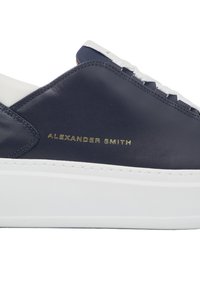 Baskets en cuir bleu marine avec des accents blancs, semelle plate blanche et nom de marque embossé en or. Présente un design simple et des coutures texturées.