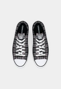 Sneaker basse a quadri neri e grigi con lacci bianchi, punta in gomma e foderatura nera, con il logo "Converse All Star".