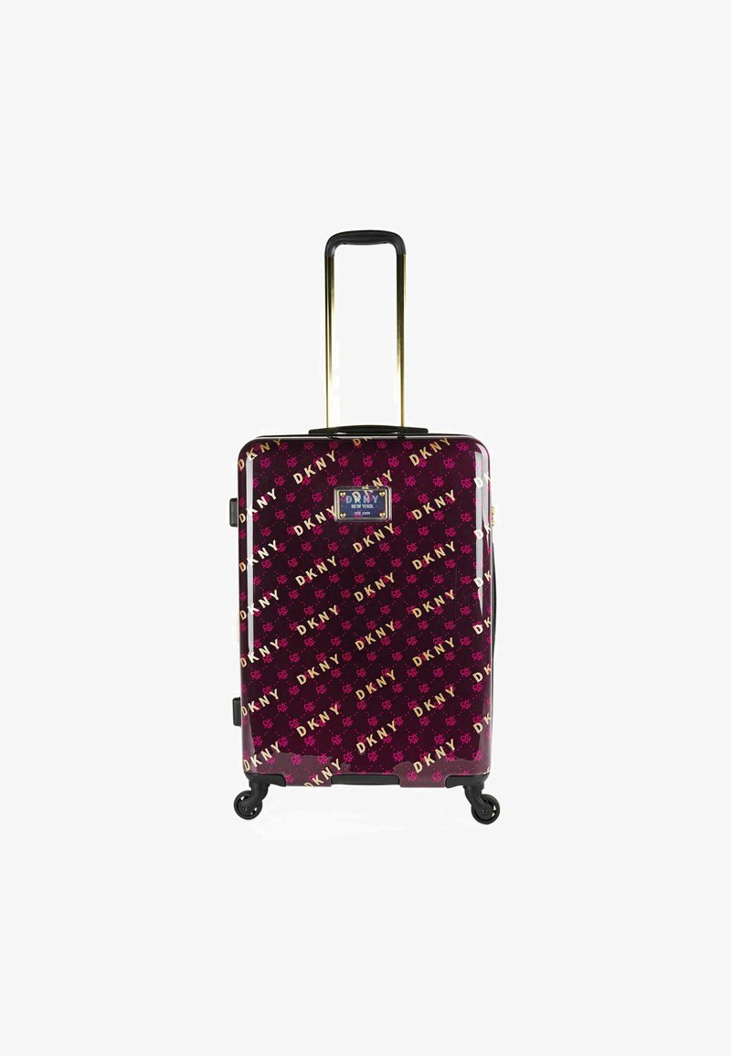 Maleta dura de color púrpura con un acabado brillante. Presenta el logo de DKNY en dorado y rosa, manija extensible y cuatro ruedas para mayor movilidad.