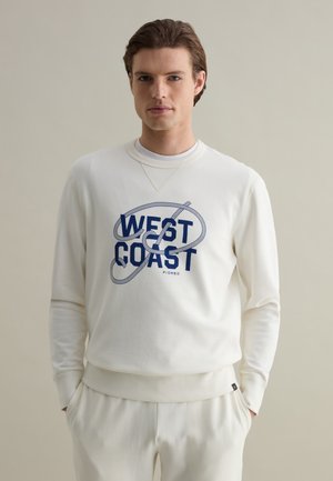 Sudadera blanca con un gráfico en azul marino que dice "WEST COAST". Cuenta con un cuello redondo, mangas largas y un acabado suave y texturizado.
