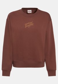 Sweatshirt marron avec un col rond et des poignets côtelés. Présente le texte "guess originals" brodé en or sur le devant. Matière douce.