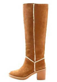 Botte haute en daim marron avec bordure en laine blanche, bout arrondi et talon épais de hauteur moyenne, vue de profil latéral.