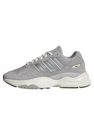 Baskets de sport grises et blanches avec un design à lacets, un col rembourré et trois bandes argentées sur le côté, sur fond blanc.