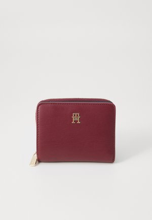 Portafoglio in pelle bordeaux con hardware dorato e logo. Forma rettangolare con chiusura a zip e superficie testurizzata per una presa migliore.