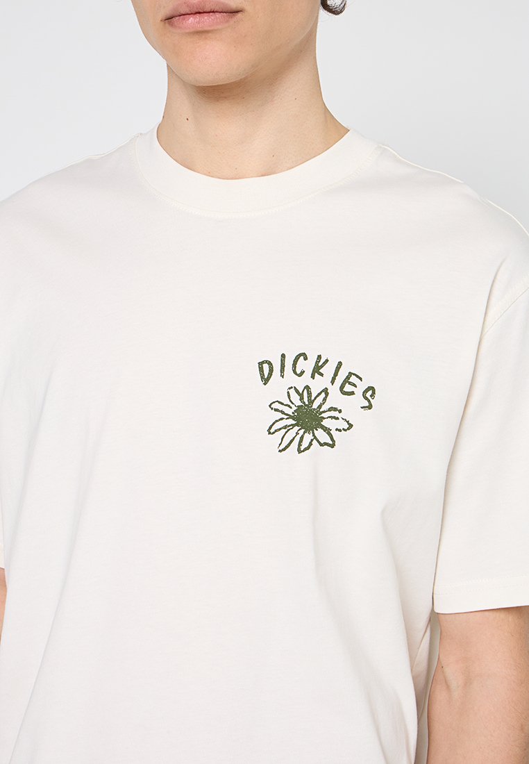 Person trägt ein weißes T-Shirt mit einem grünen Gänseblümchen-Motiv und dem Wort "DICKIES" darüber auf der linken Brust.