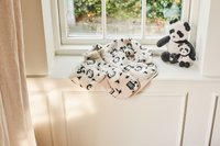 Λευκό μπουφάν φλις με εκτύπωση πάντα, κλείσιμο με φερμουάρ, τοποθετημένο σε παράθυρο δίπλα σε δύο μαλακά παιχνίδια πάντα σε μαύρο και λευκό.