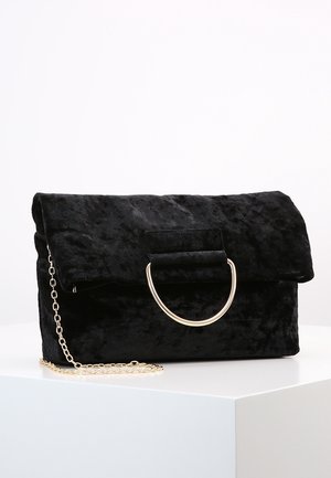 Borsa a pochette in velluto nero con patta ripiegabile, hardware circolare dorato e tracolla removibile. Texture morbida con una leggera lucentezza.