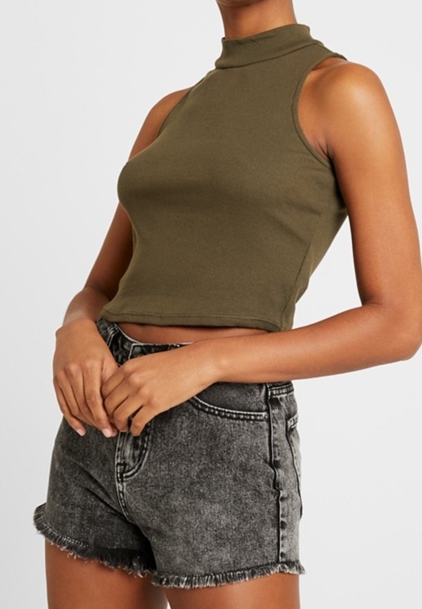 Top court sans manches vert olive associé à un short en denim noir taille haute effet délavé acide avec ourlets effilochés.