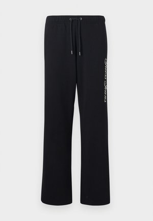 Pantalones de chándal negros hechos de un material suave, con una cinturilla elástica y un cordón. Presenta texto impreso en blanco en un lado.